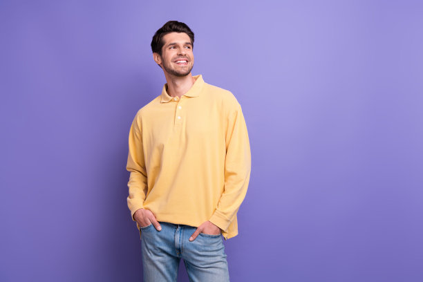 照片中若有所思的男人穿着黄色衬衫，看起来空无一物，孤立的紫色背景图片下载