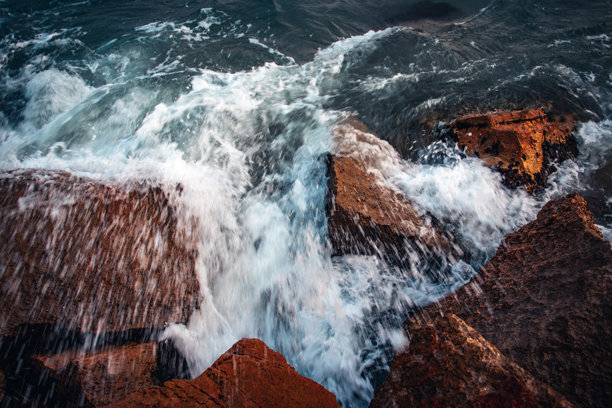 近距离的水与石头在海滩上的概念照片。波涛汹涌的大海，海浪，水下的鹅卵石。图片下载