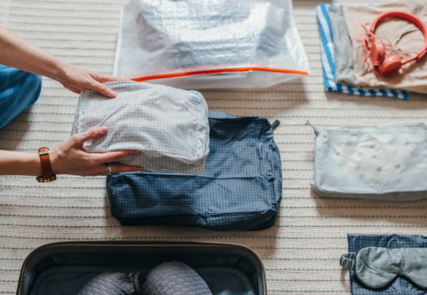 女人的手在家里收拾行李箱的特写照片图片下载