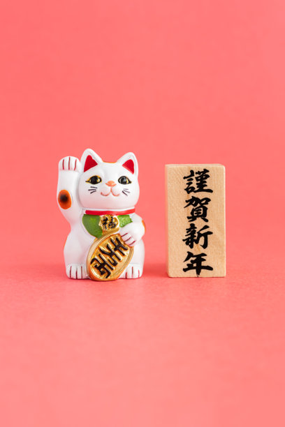 招财猫与新年快乐的日文。日本新年背景素材，留有空白空间。图片下载