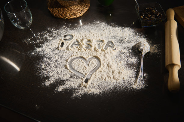 手绘的信息和心形图案在黑色厨房台面上的面粉中图片下载