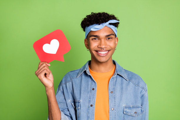 帅气男士微笑着在明亮的绿色背景下做出社交媒体点赞手势的照片肖像图片下载