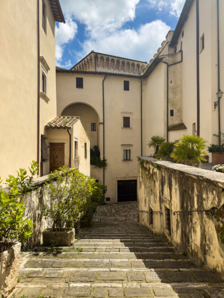 宁静的复古照片，展示了石阶和历史建筑，绿意盎然，蓝天映衬。文化遗产概念。非常适合旅游广告和室内设计。图片下载