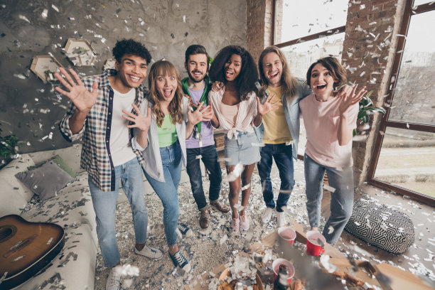 一群积极快乐的朋友在室内聚会时微笑的全身照片图片下载