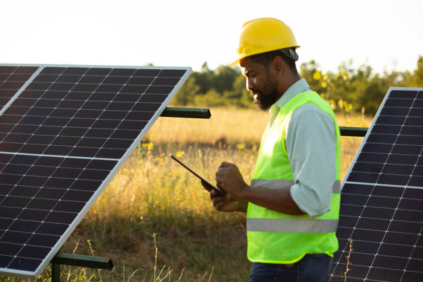 工程师在太阳能农场使用数字平板电脑检查太阳能电池板。库存图片图片下载