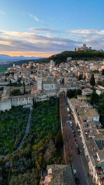 日落时分的阿西西老城鸟瞰图，包含马焦雷城堡、圣彼得教堂和中世纪建筑，意大利翁布里亚，历史悠久的山坡小镇和金色时光旅行照片内容图片下载