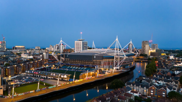 夜间的卡迪夫市中心航拍照片，展示了威尔士王子体育场、卡迪夫武器公园和塔夫河。图片下载