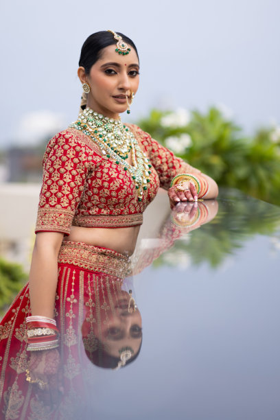 非常美丽的年轻印度新娘在户外穿着奢华的婚礼服装，化着妆，佩戴着华丽的珠宝的肖像照片图片下载