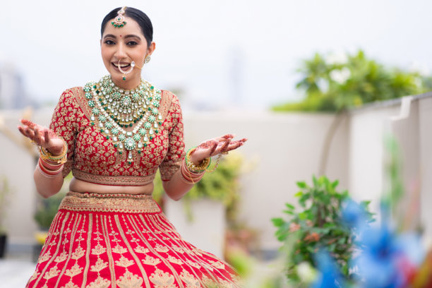 非常美丽的年轻印度新娘在户外穿着奢华的婚礼服装，化着妆，佩戴着华丽的珠宝的肖像照片图片下载