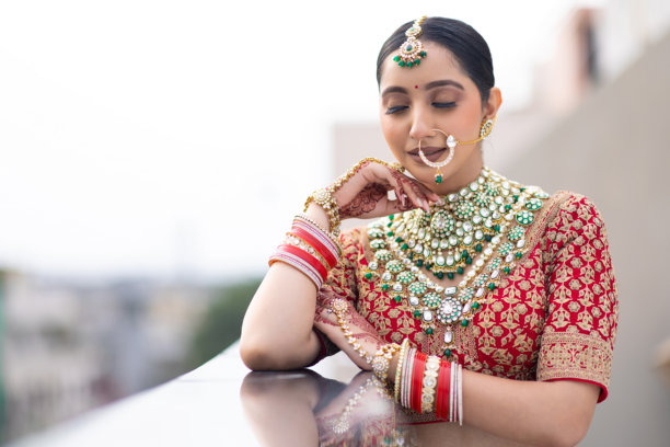 非常美丽的年轻印度新娘，身着奢华的婚礼服装，化着妆，佩戴着华丽的珠宝，户外拍摄的肖像照片图片下载