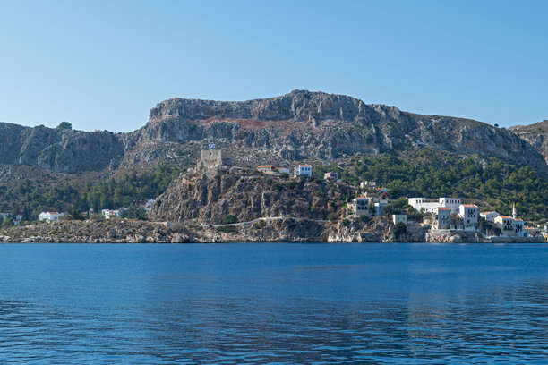 沐浴在地中海阳光下，这张照片捕捉了希腊梅斯岛的壮观海岸悬崖和历史遗迹，非常适合以旅行、自然和文化遗产为主题的视觉内容。图片下载