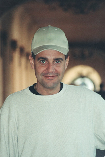 1980年代拍摄的照片：年轻男子戴着帽子微笑着看向镜头图片下载