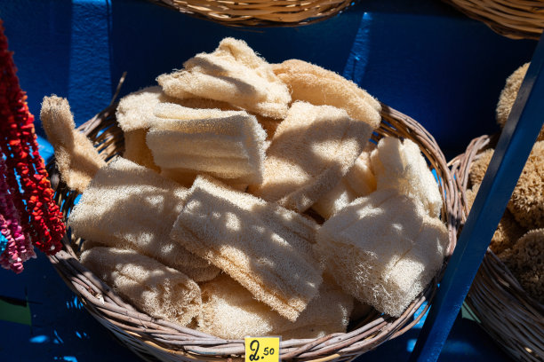 一个色彩斑斓的市场摊位，摆满了天然海绵，位于希腊罗德岛热闹的街道上。非常适合以地中海文化、手工艺和海滨旅游为主题的视觉素材。图片下载