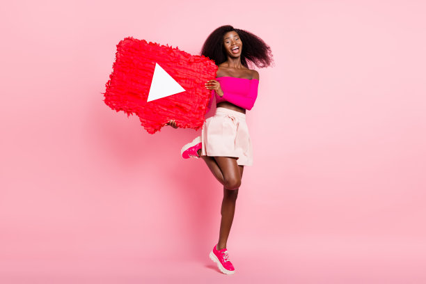 乐观的棕发女孩穿着粉色上衣和裙子，手持玩具，跳舞的全身侧面照片，背景为柔和的色彩。图片下载