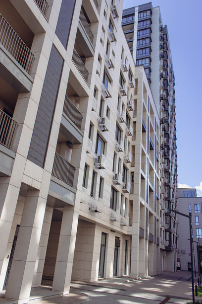 市中心区域有树木和草坪。阳光明媚的日子里高楼大厦。现代建筑。商务办公楼。建筑中的几何线条。现代建筑外观。图片下载