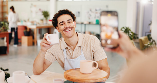 陶艺课程，照片和陶瓷工作室中的男子，在线发布，成就和陶土产品。手机、社交媒体和工作室中的男士，获得支持、反馈以及雕塑设计模具或微笑。图片下载