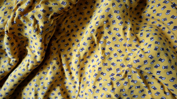 印刷面料制成的照片背景。图案由杂乱放置在黄色背景上的线团组成。图片下载