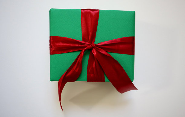 白色背景上的礼物。绿色方形盒子，配有红色丝带和蝴蝶结。照片图片下载