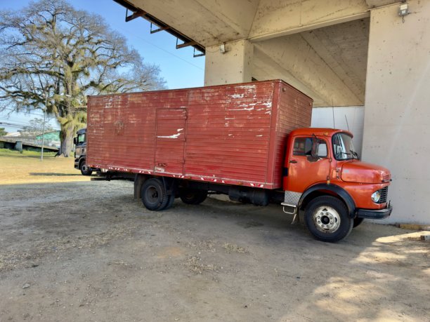 老旧的卡车停在开放区域的混凝土结构下。逼真的照片展现了城市和复古氛围，适合运输、物流、公路运输历史和经典货运车辆的主题。图片下载