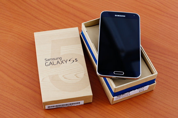全新三星Galaxy S5智能手机在木质表面上拆包图片下载