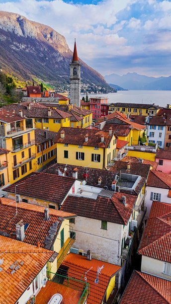 从空中俯瞰科莫湖东岸五彩斑斓的瓦伦纳村，教堂塔楼、山地风光和滨水长廊，传统建筑与意大利北部伦巴第的旅行概念。图片下载