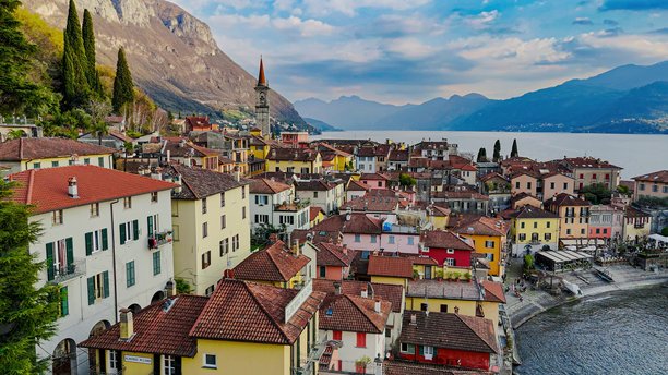 从空中俯瞰科莫湖东岸五彩斑斓的瓦伦纳村，教堂塔楼、山地风光和滨水长廊，传统建筑与意大利北部伦巴第的旅行概念。图片下载