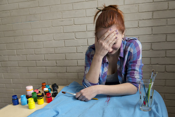 女孩在蓝色衣服上用丙烯颜料绘画的照片图片下载