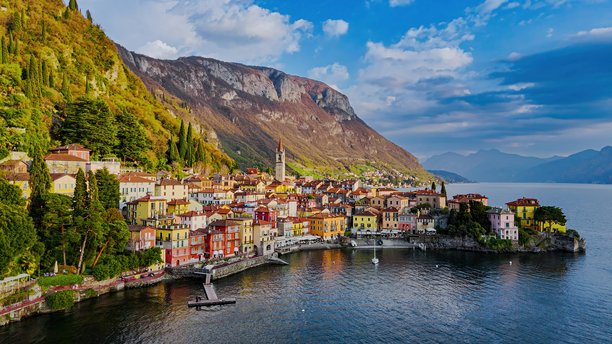 从空中俯瞰科莫湖东岸五渔村的多彩村庄，教堂塔楼、山地风光和滨水长廊，传统建筑和意大利北部伦巴第的旅行概念。图片下载