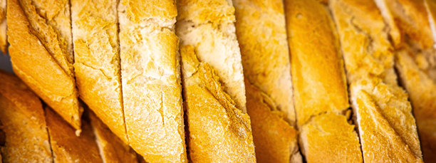 新鲜香气四溢的面包摆放在桌上。面包店食品概念全景或宽幅横幅照片背景图片下载