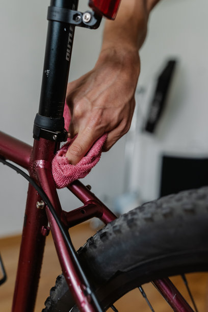 骑自行车的男子用超细纤维布清洁山地车的车架，确保其保持完美状态和良好维护。图片下载