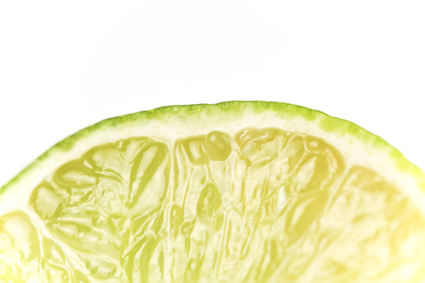 切开的绿色柠檬特写照片，白色干净背景图片下载