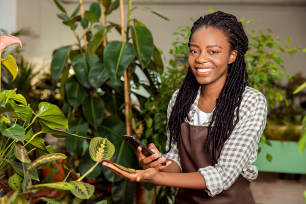 花店助手拍摄植物照片并微笑图片下载
