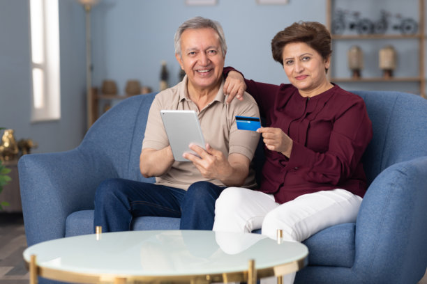 老年夫妇在家沙发上网上购物的照片图片下载