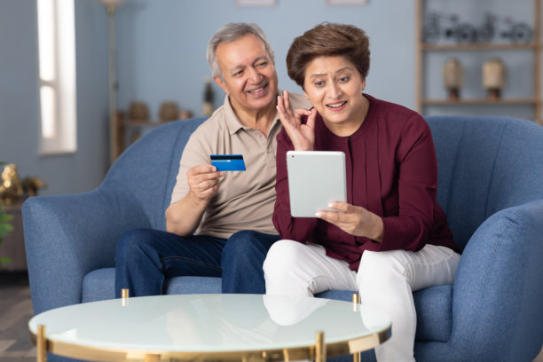 老年夫妇在家沙发上网上购物的照片图片下载