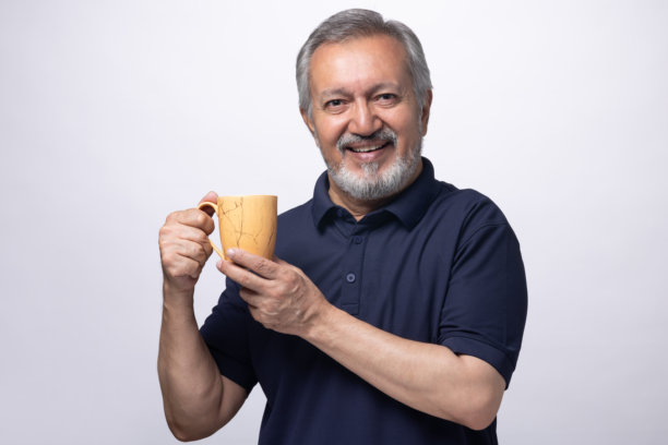 老年男子在白色背景下喝咖啡的肖像照片图片下载