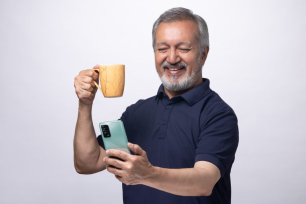 老年男子在白色背景下喝咖啡的肖像照片图片下载