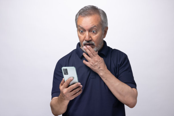 老年男性在白色背景上使用手机的库存照片图片下载