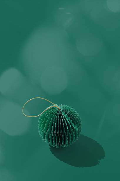 节日纸质圣诞装饰品，圆形球体，悬挂的绿色新年球，蜂巢状斯堪的纳维亚风格装饰，绿色背景，简约单色照片，冬季节日贺卡，留白，竖版图片下载