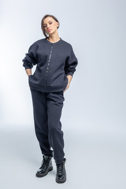 美丽的模特外貌女性。穿着黑色衣服的女孩在灰色背景前。时尚妆容的漂亮女性在摄影棚中摆姿势。竖版照片。图片下载