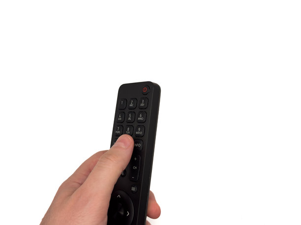白人男性的手在白色背景上按压电视遥控器的按钮，男子用遥控器切换电视频道，适用于横幅和电视广告。留白，平铺，俯视图。图片下载