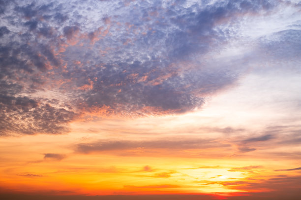 美丽的日落景观，奢华柔和的渐变橙金色云朵和阳光映照在蓝色戏剧性的天空上，完美适合作为背景，早晨、傍晚、黄昏，气候变化，横向日落照片图片下载