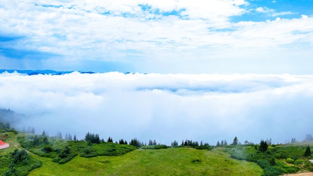 高地村庄的航拍FPV照片，散落在戈雷莱（Giresun）郁郁葱葱的绿色山丘和山谷中，传统的乡村聚落在黑海地区的多云夏日天空下，展现自然与文化旅游的概念。图片下载