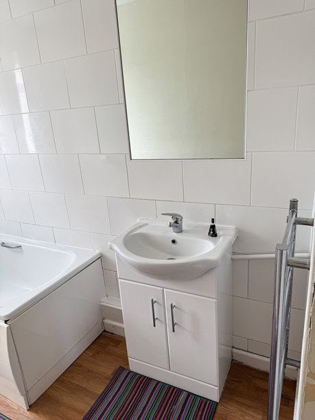 现代浴室的图片，配有白色光面梳妆台、洗手盆、水龙头、不锈钢水龙头、梯形暖气片和墙面镜子。图片下载