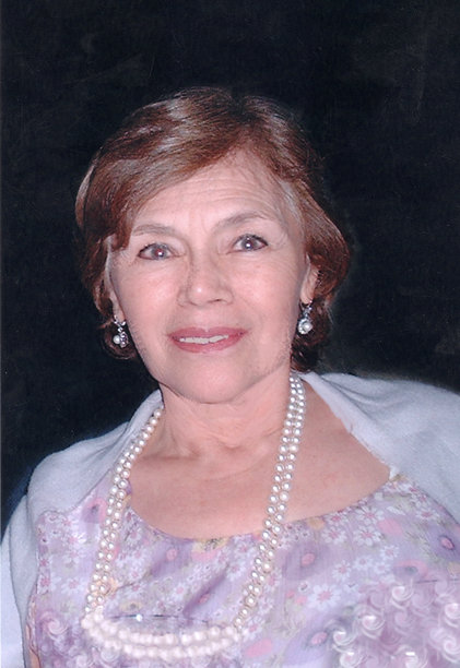 1980年代拍摄的照片，微笑的年长女性在家庭活动中看向镜头摆姿势。图片下载