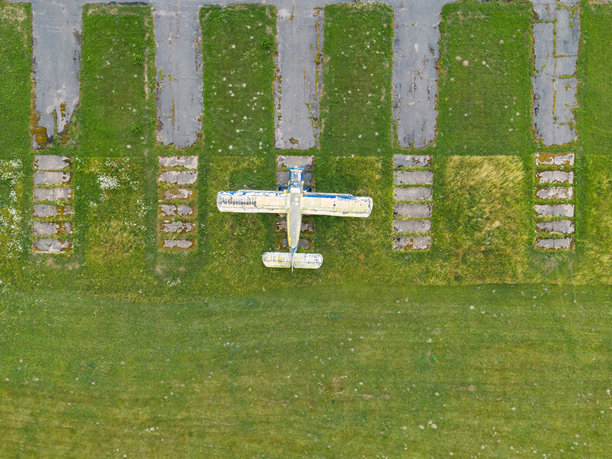 一架废弃的飞机停在一个旧机场，这是夏天无人机拍摄的照片。图片下载