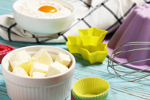 烘焙用具和配料。彩色硅胶纸杯蛋糕盒，饼干模具 在一个蓝色的木制背景。复活节的概念。图片下载