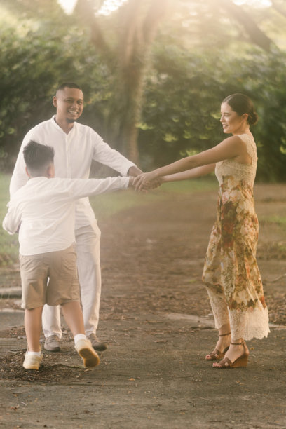 在新加坡拍摄的国际家庭照片，11岁的孩子微笑。亚洲父亲和儿子，白人母亲。郁郁葱葱的热带背景。图片下载