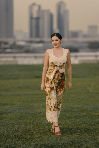 优雅的棕发女性，肤色白皙，身材纤细，穿着花卉连衣裙在热带新加坡摆姿势。美学肖像，背景为郁郁葱葱的异国风情。图片下载