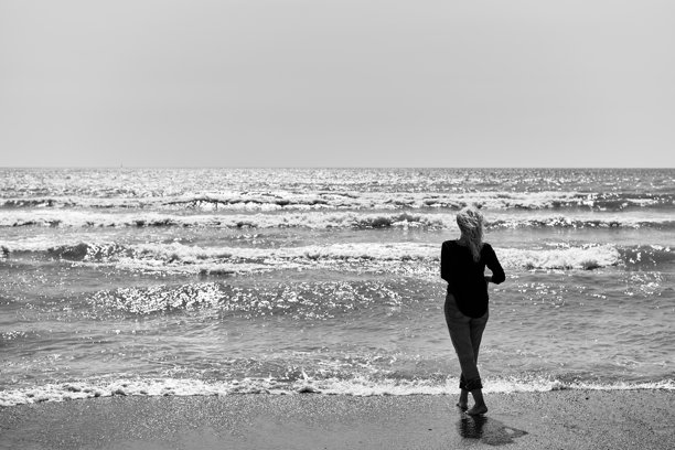 黑白照片成熟的金发女人在海边散步图片下载