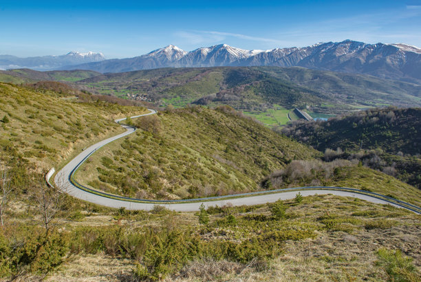 阿布鲁佐意大利的自然公园坎波托斯托，背景是雪顶山脉的绿色山地公路穿越风景。图片下载